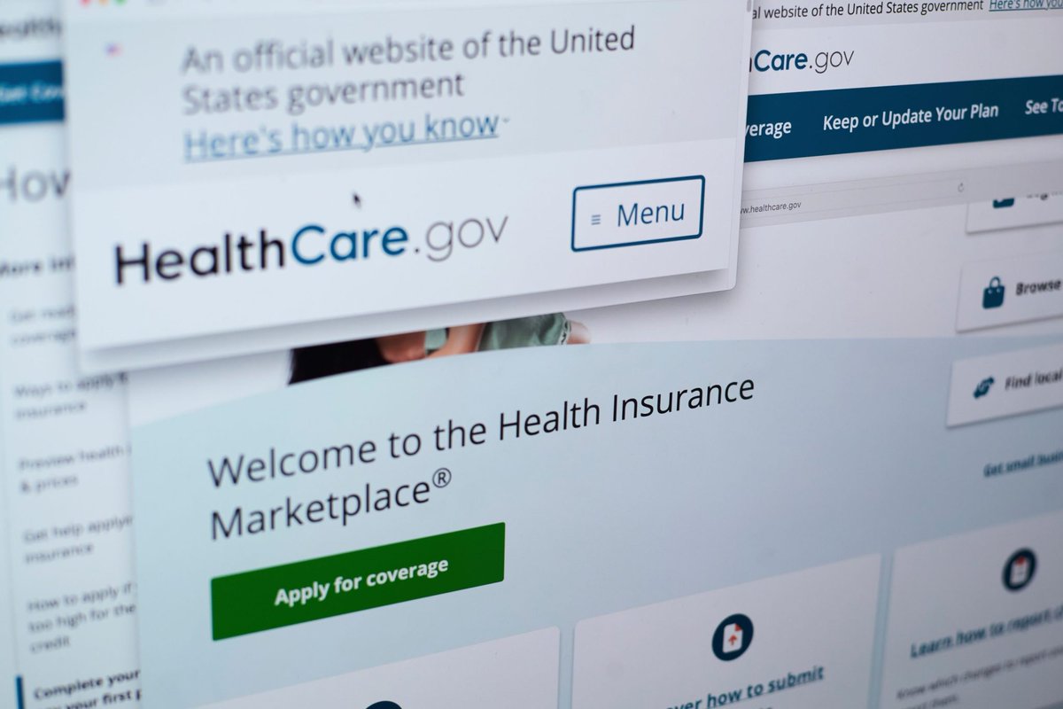 A couple reviews bills at home; potential ACA premium increases if enhanced tax credits expire.