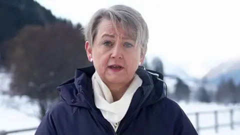 Yvette Cooper speaking to BBC Breakfast from Davos, Switzerland, wearing a blue coat and white scarf against a snowy backdrop