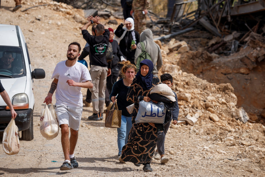 Displaced residents cross a damaged bridge linking southern Lebanon to the rest of the country after earlier strikes.