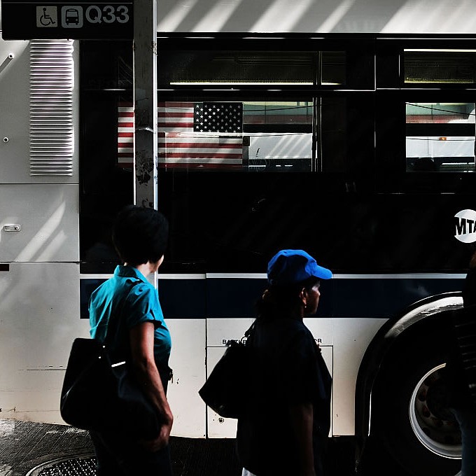 Riders pass an MTA shuttle bus as the LIRR strike stretches into a third day. - CBS News