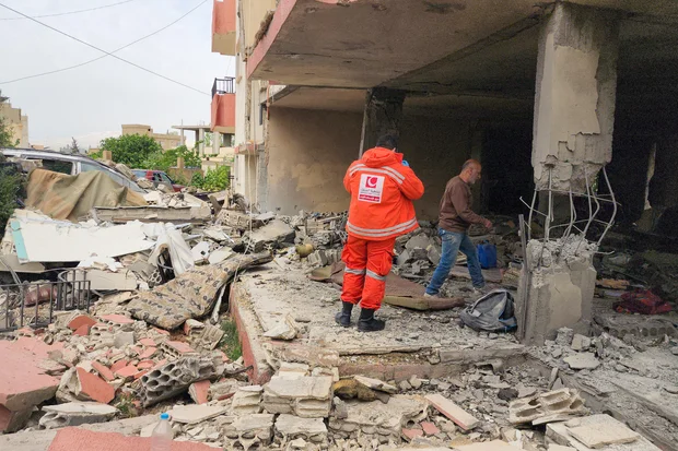 Rescue worker amid rubble in a Middle East conflict zone