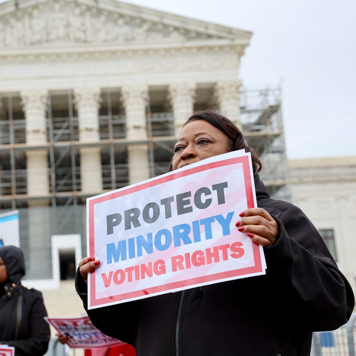 A demonstrator holds a sign saying "PROTECT MINORITY VOTING RIGHTS" at a March 2025 rally outside the U.S. Supreme Court in Washington, D.C. - Jemal Countess/Getty Images for Legal Defense Fund